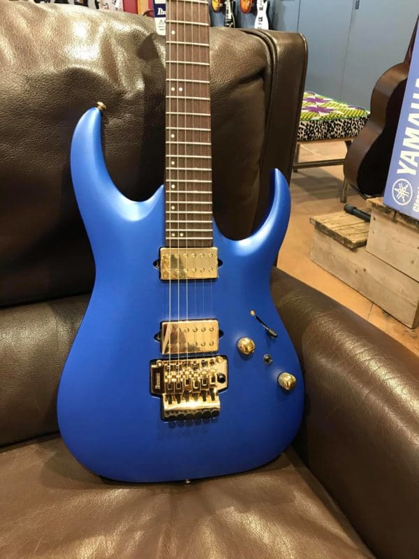 guitare électrique bleue posée sur canapé marron