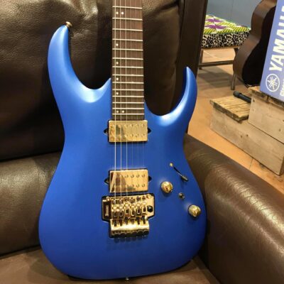 guitare électrique bleue posée sur canapé marron