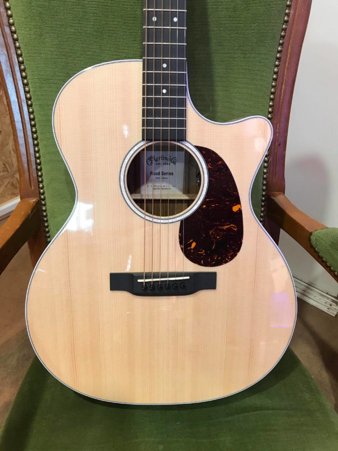guitare folk électro posée sur fauteuil vert