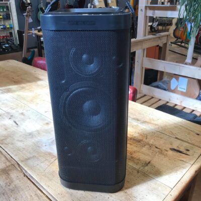 enceinte portative noire posée sur table bois