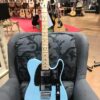 guitare électrique bleu posée sur fauteuil